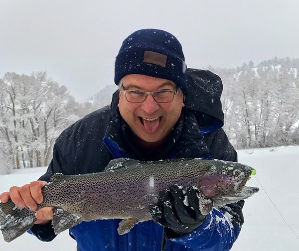 A very happy Richard Presnel holds a huge catch of a trout in the snow.