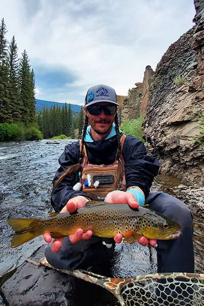 Joe Miller holding a nice rainbow trout on a river near Lake City.