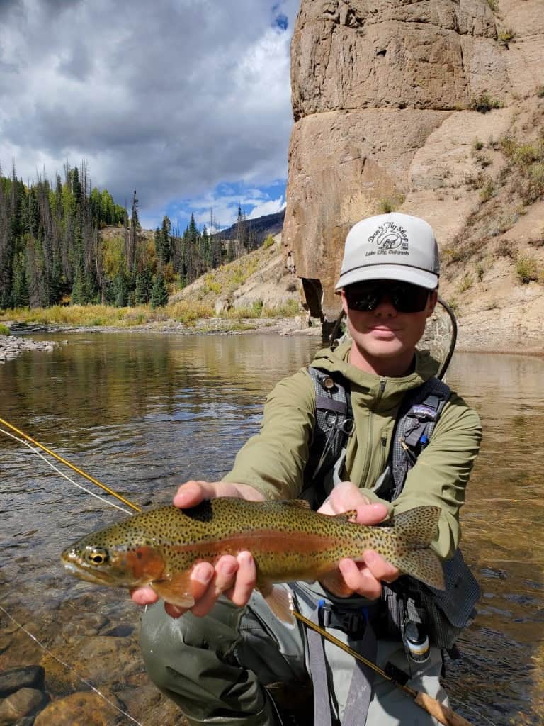 DFS guide, Grant Keck, shows off a beauty of a trout from beneath the cliffs of the Lake Fork of the Gunnison River.