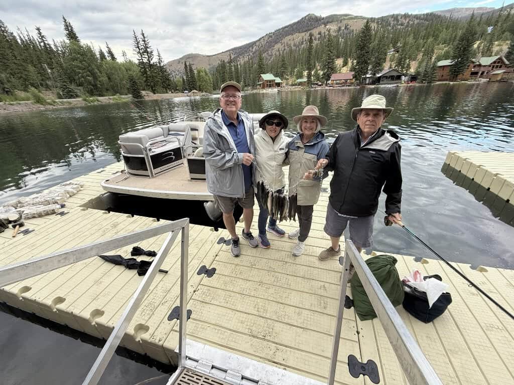 Two couples hold a string on nice lake trout caught from the DFS pontoon at the dock at Lake San Cristobal.
